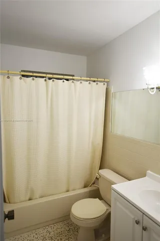 a white toilet sitting next to a shower curtain