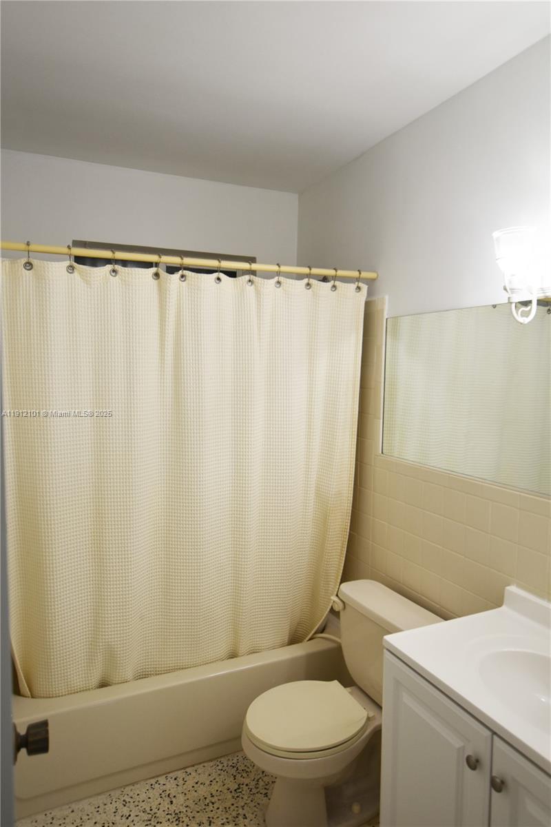 1532 Southwest 23rd Street, Unit 1532 Miami, FL 33145 - Photo 9 of 11 a white toilet sitting next to a shower curtain