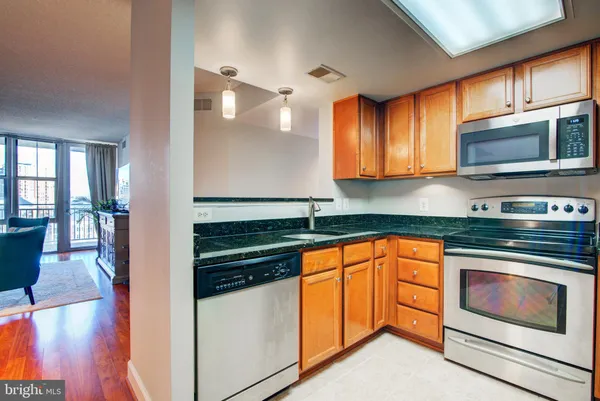 a kitchen with stainless steel appliances granite countertop a stove a sink and a microwave