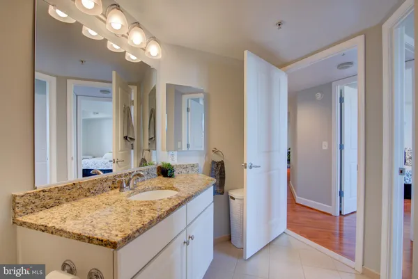 a bathroom with a granite countertop sink and a mirror