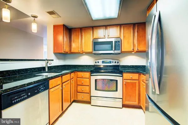 a kitchen with stainless steel appliances granite countertop a stove a sink and a microwave
