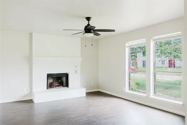 a view of main area fire place window and wooden floor