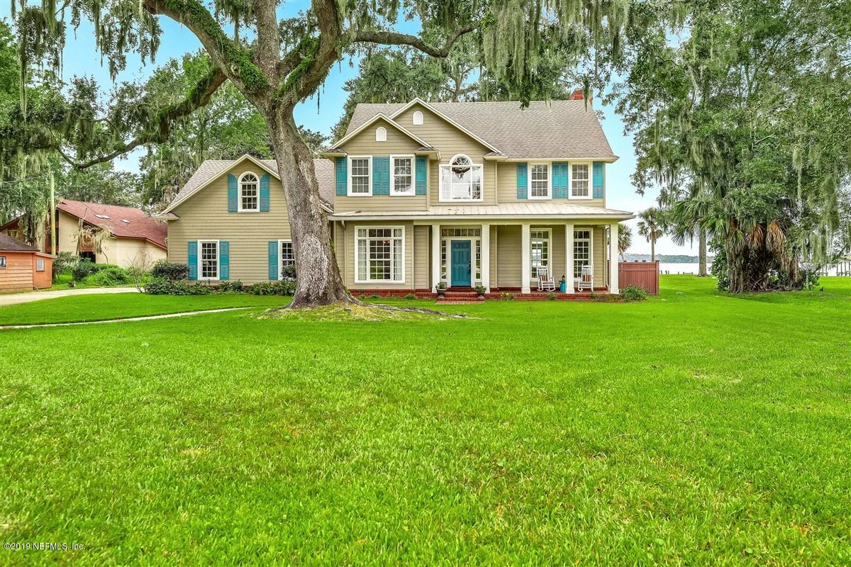 a front view of a house with a garden and trees