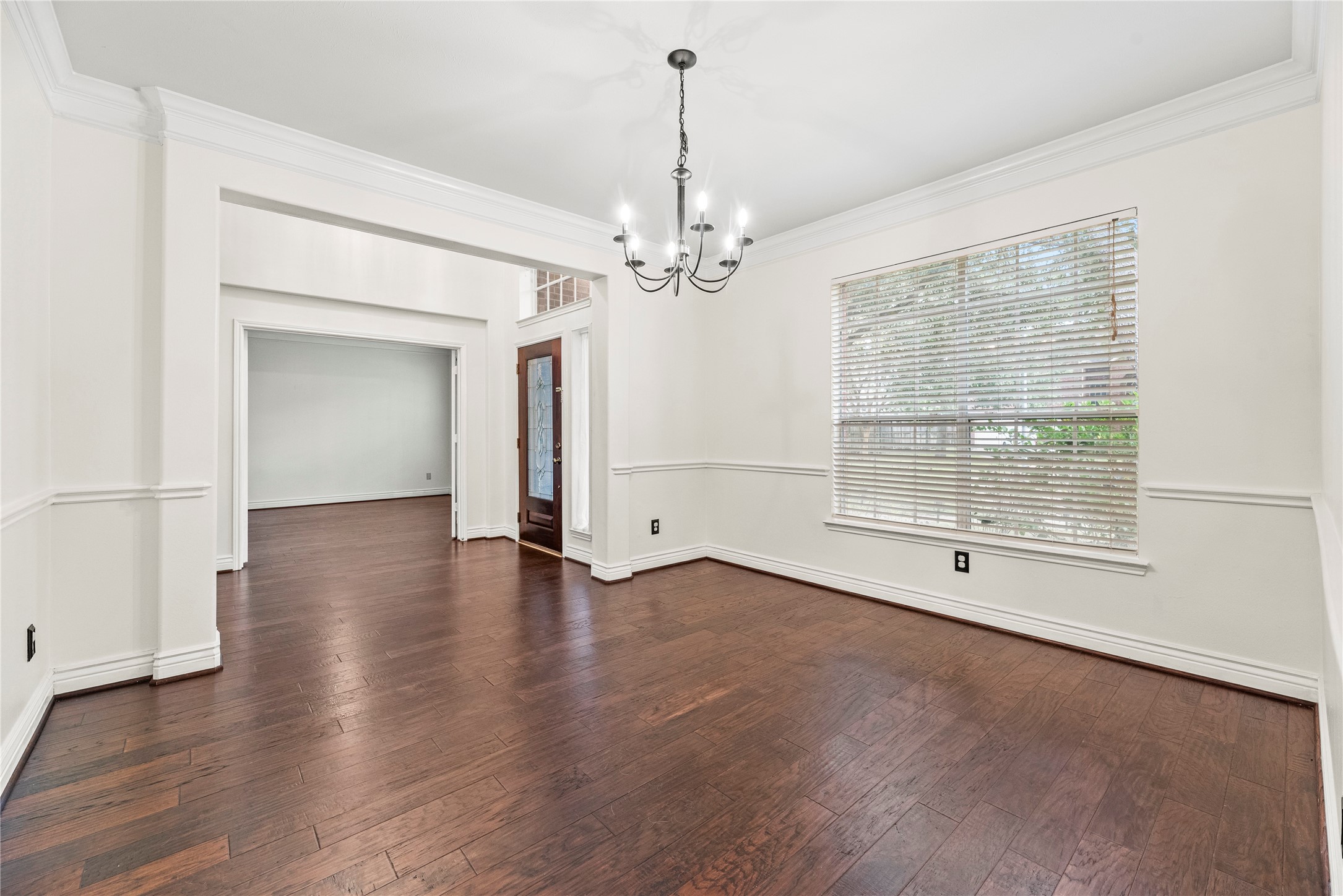402 Spring Trace Court Houston, TX 77094 - Photo 5 of 35 an empty room with wooden floor chandelier and windows
