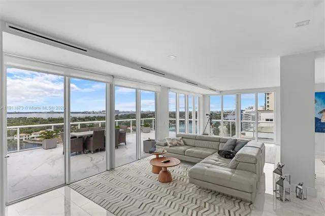 a living room with furniture and a view of kitchen