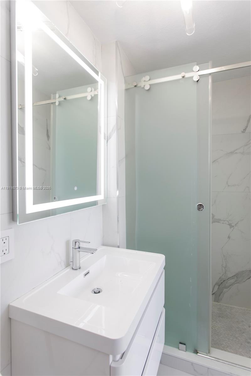 5001 Collins Avenue, Unit PH1 Miami Beach, FL 33140 - Photo 33 of 82 a bathroom with a sink and shower