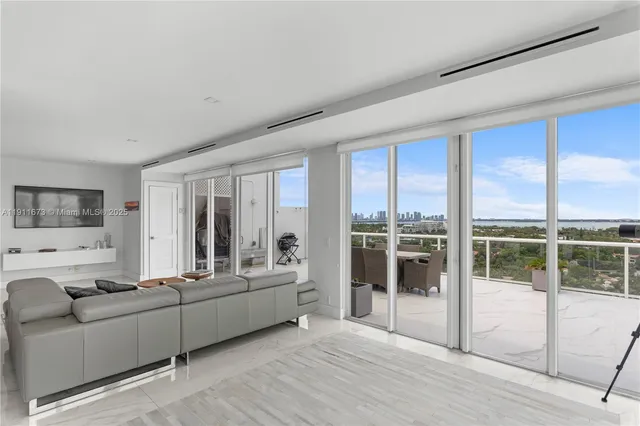 a living room with stainless steel appliances kitchen island granite countertop furniture and a fireplace