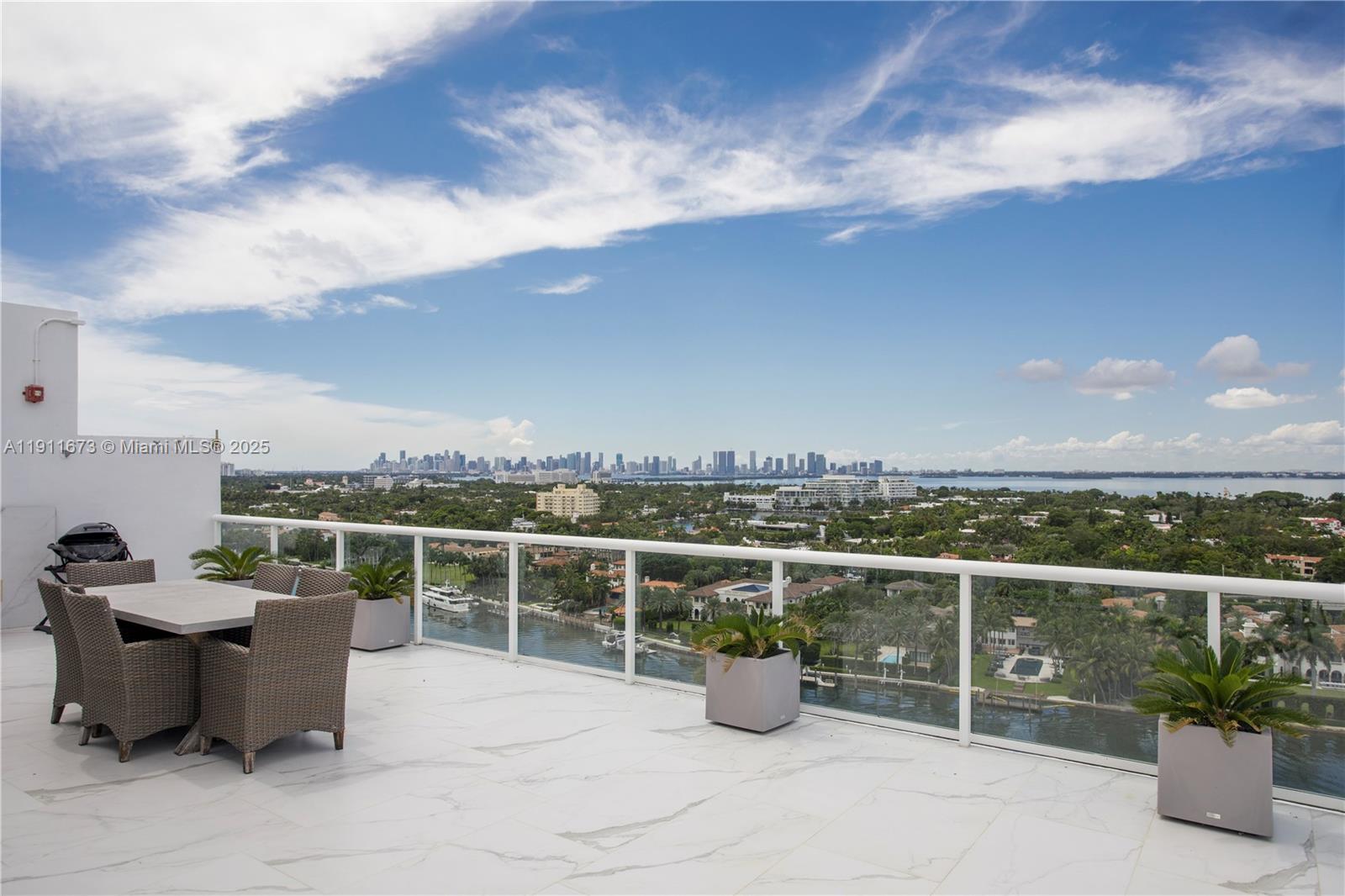 5001 Collins Avenue, Unit PH1 Miami Beach, FL 33140 - Photo 44 of 82 a view of a roof deck with a table and chairs with wooden fence