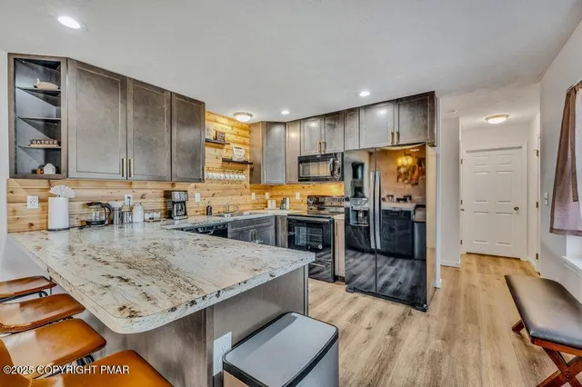 a view of a kitchen with kitchen island a counter space a sink appliances and cabinets