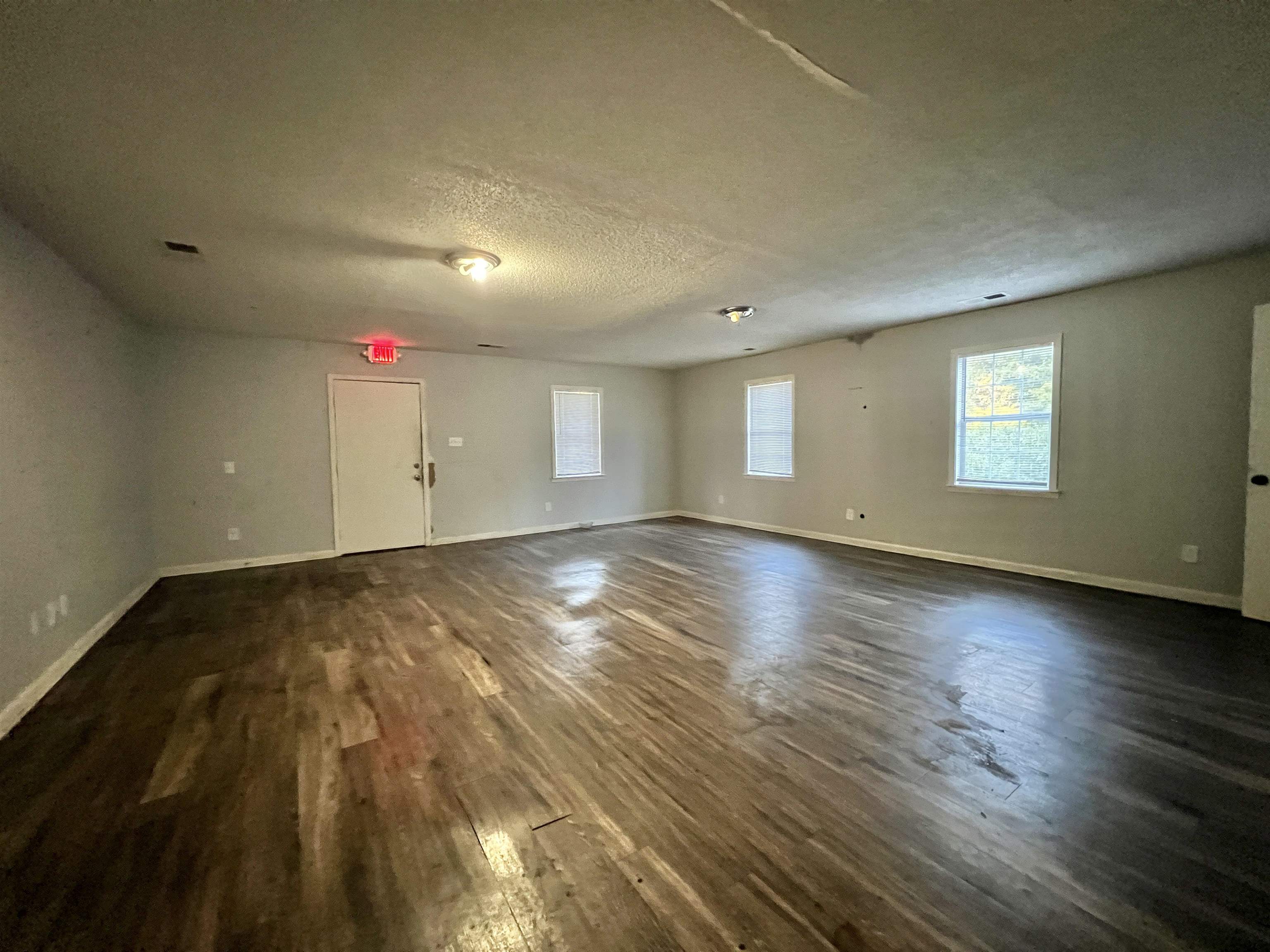 3804 Cazassa Road Memphis, TN 38116 - Photo 9 of 17 Unfurnished room featuring dark wood finished floors, healthy amount of natural light, and a textured ceiling