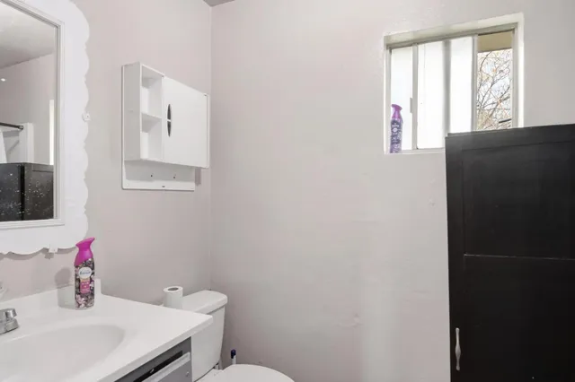 a bathroom with a sink toilet and window