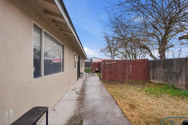 a view of a pathway of a house with wooden fence