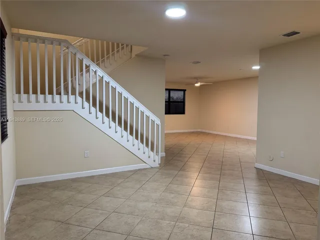 a view of hallway with a window and a refrigerator