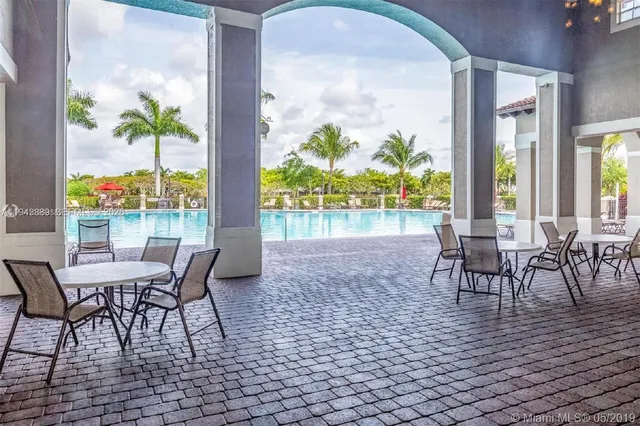 a view of a backyard with potted plants and large trees