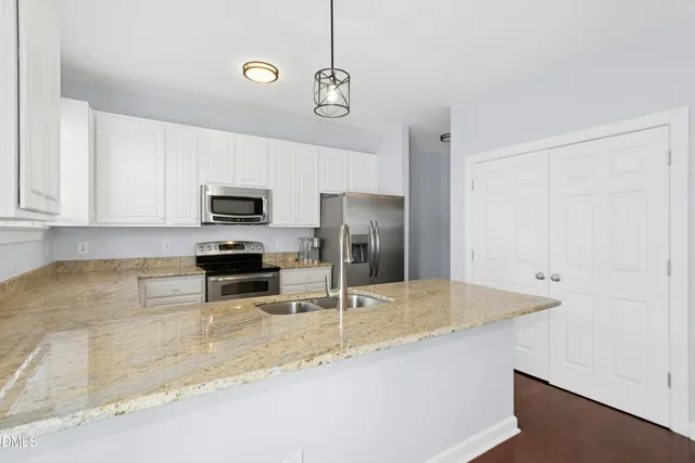 a kitchen with stainless steel appliances granite countertop a sink a stove and microwave