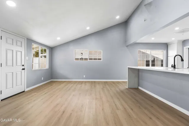 a view of a kitchen with wooden floor and a sink