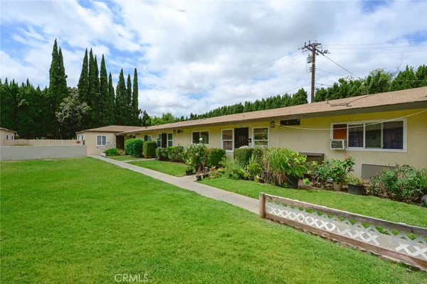 a front view of a house with a yard and potted plants