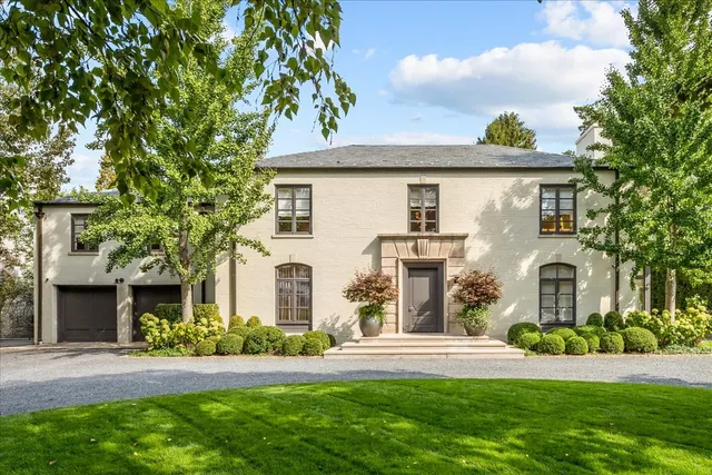 a front view of a house with a yard and potted plants