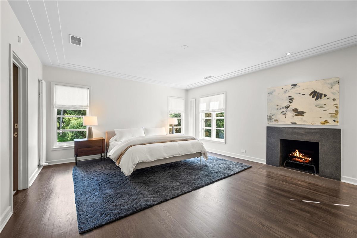 1106 Seneca Road Wilmette, IL 60091 - Photo 43 of 79 a bed sitting in a spacious bedroom next to a window with a fireplace