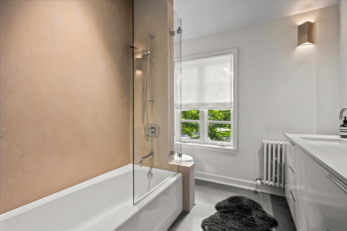 1106 Seneca Road Wilmette, IL 60091 - Photo 56 of 79 a bathroom with a tub a sink and a window