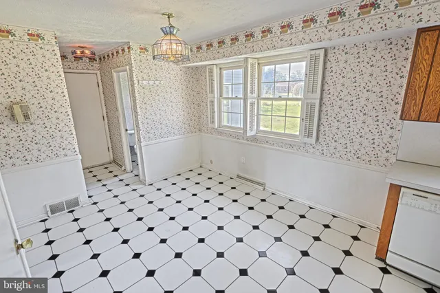 a view of an empty room with a fireplace and a window