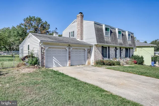 a front view of a house with a garden and yard