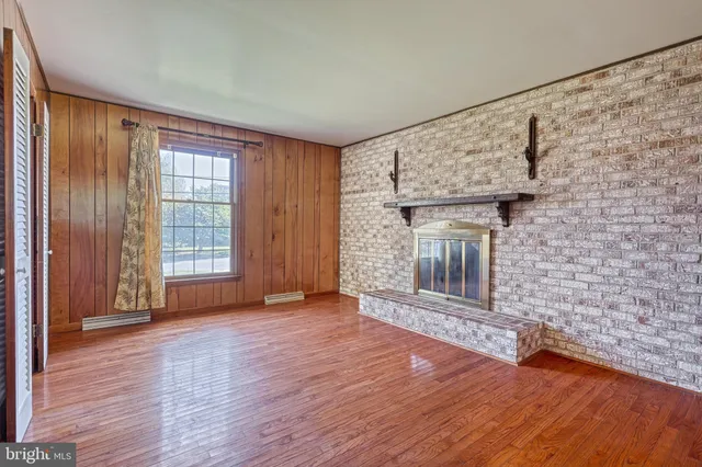 a bathroom with a toilet a sink a mirror and a window
