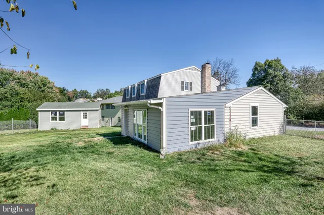 a aerial view of a house with a yard balcony and large trees