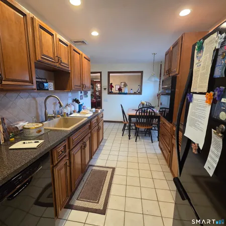 a open kitchen with stainless steel appliances granite countertop a stove a sink dishwasher and cabinets with wooden floor