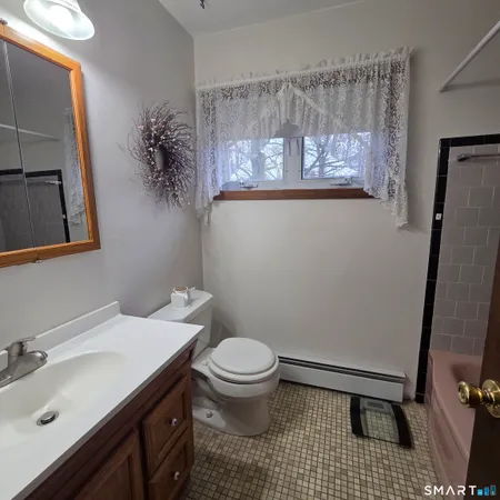 a bathroom with a sink a toilet a mirror and shower