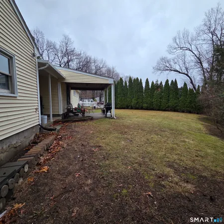 a view of a house with backyard and trees