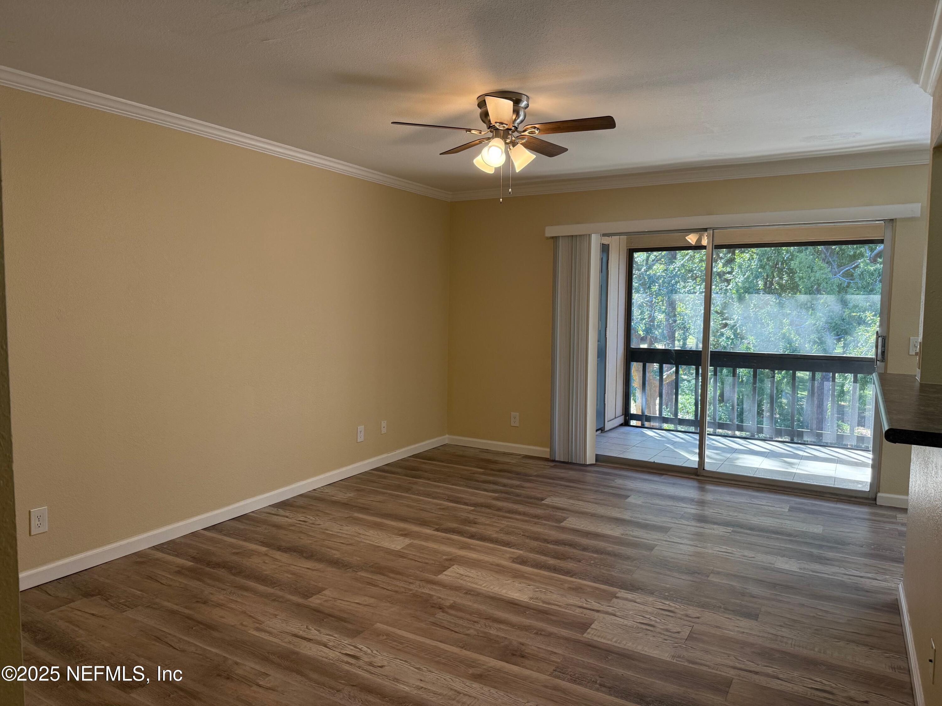 8880 Old Kings Road South, Unit 6 Jacksonville, FL 32257 - Photo 3 of 27 a view of an empty room with wooden floor and fan