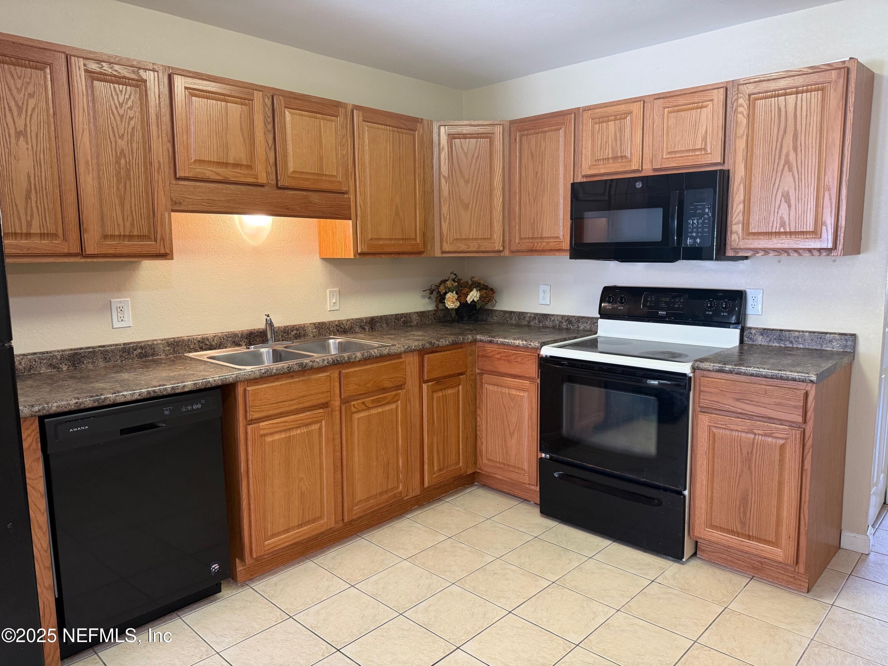 8880 Old Kings Road South, Unit 6 Jacksonville, FL 32257 - Photo 6 of 27 a kitchen with granite countertop a stove top oven microwave and cabinets