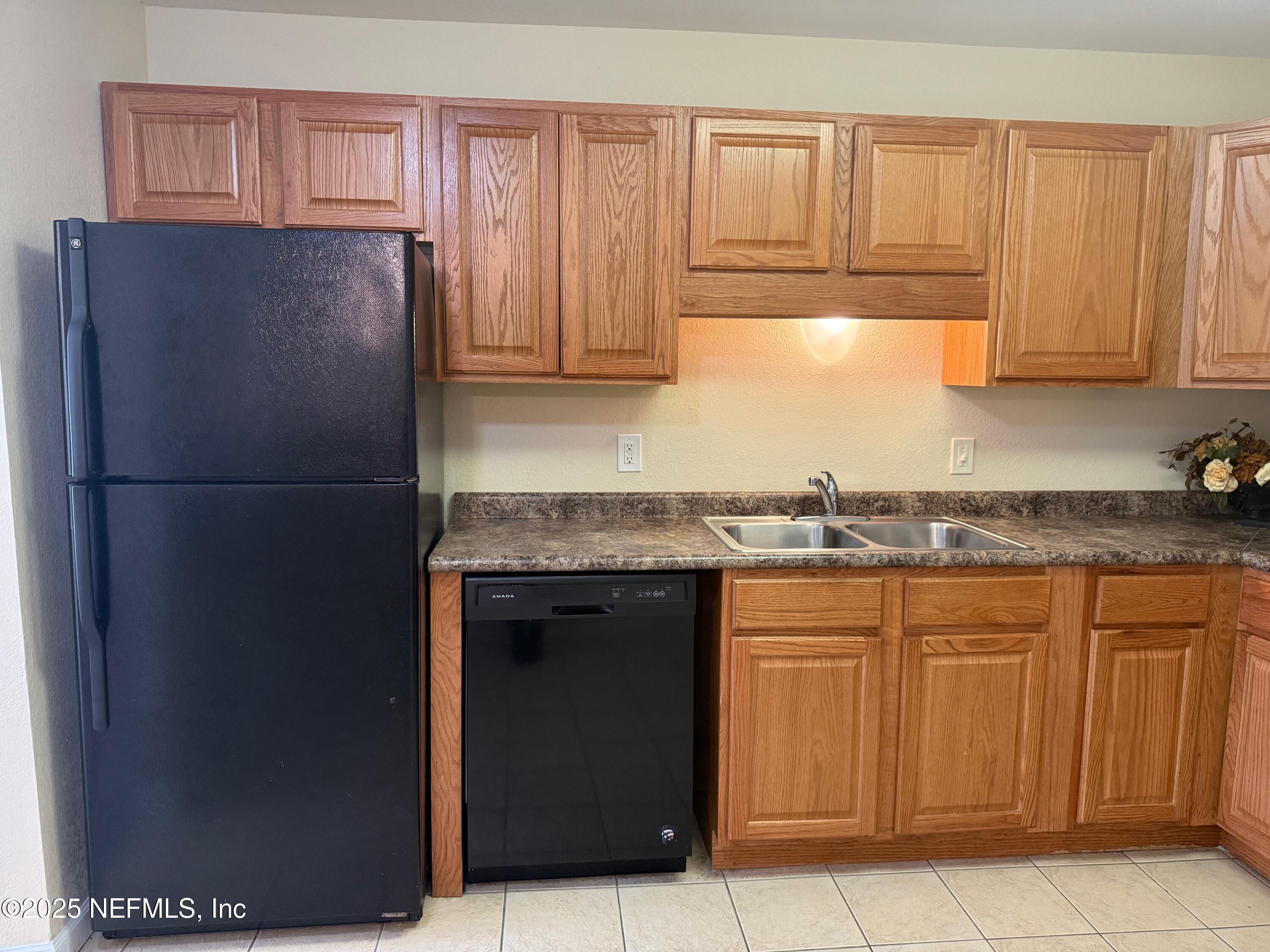 8880 Old Kings Road South, Unit 6 Jacksonville, FL 32257 - Photo 7 of 27 a kitchen with stainless steel appliances granite countertop a refrigerator and a sink