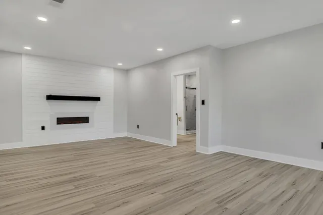 a view of a hallway with wooden floor and cabinet