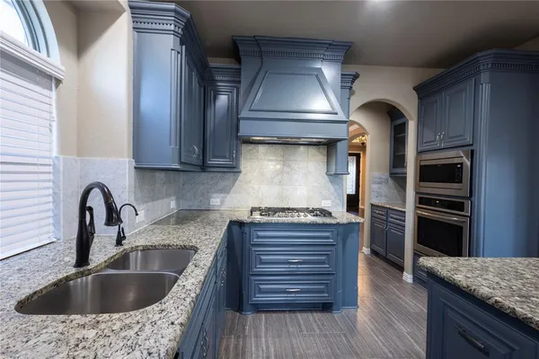 a kitchen with stainless steel appliances granite countertop a sink and a stove
