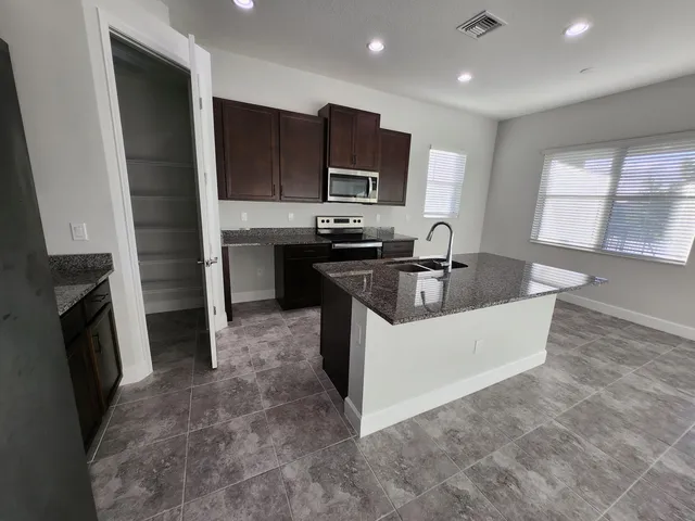 an empty room with windows and fireplace