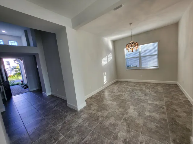 an empty room with windows and ceiling fan