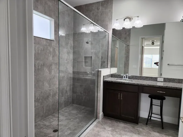 a bathroom with a granite countertop sink and a mirror