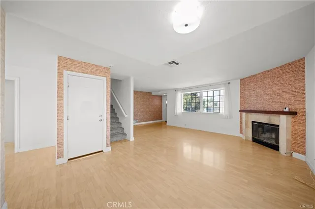 an empty room with windows and fireplace