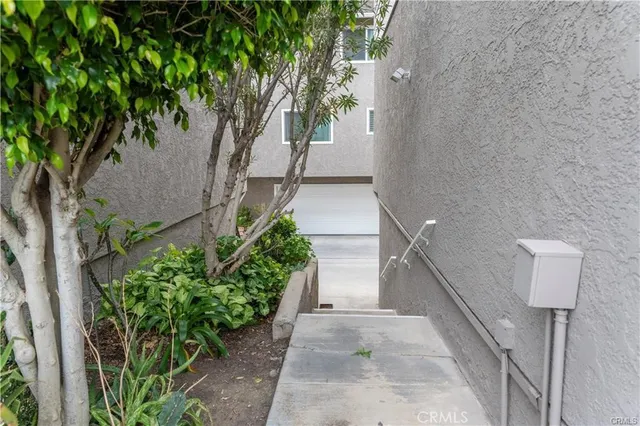 a view of a pathway of a house with wooden fence