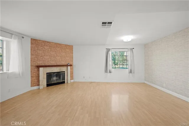 an empty room with windows and fireplace