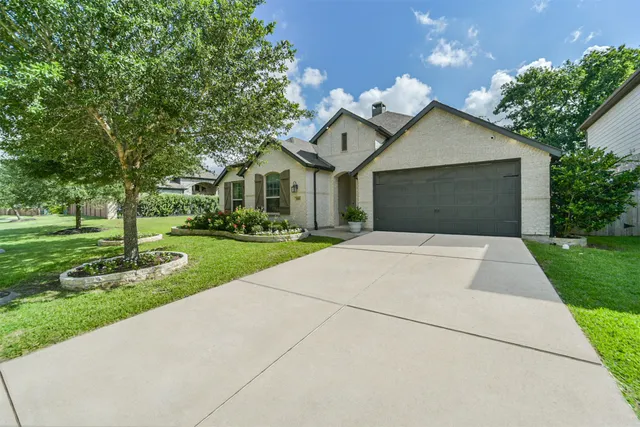 a front view of a house with a yard and trees