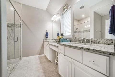 a bathroom with a granite countertop sink mirror and shower
