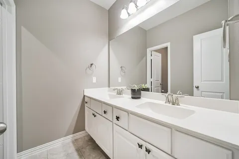 a bathroom with a double vanity sink and a mirror
