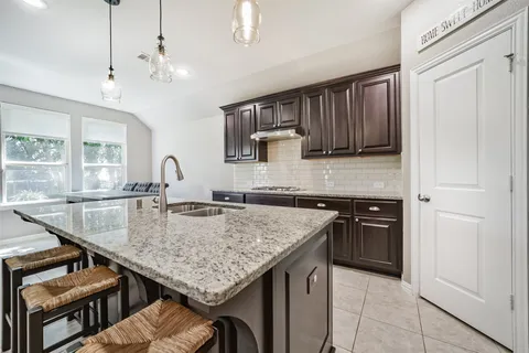 a kitchen with stainless steel appliances granite countertop a stove top oven a sink and dishwasher