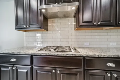 a kitchen with granite countertop a sink stainless steel appliances and cabinets
