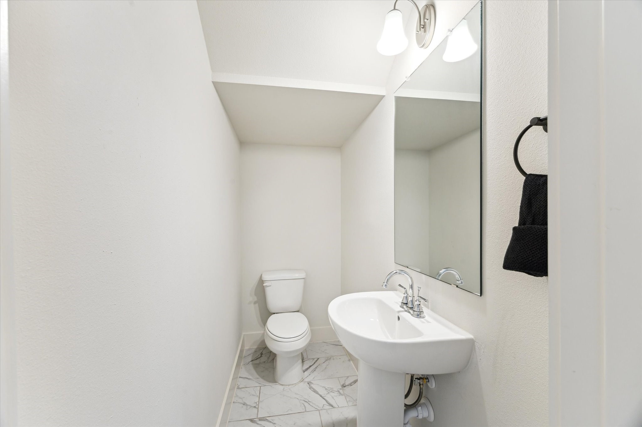 4155 Griggs Road Houston, TX 77021 - Photo 6 of 17 Chic first-floor half bath with a pedestal sink, sleek fixtures, and a crisp, clean design—perfectly blending function with modern simplicity.