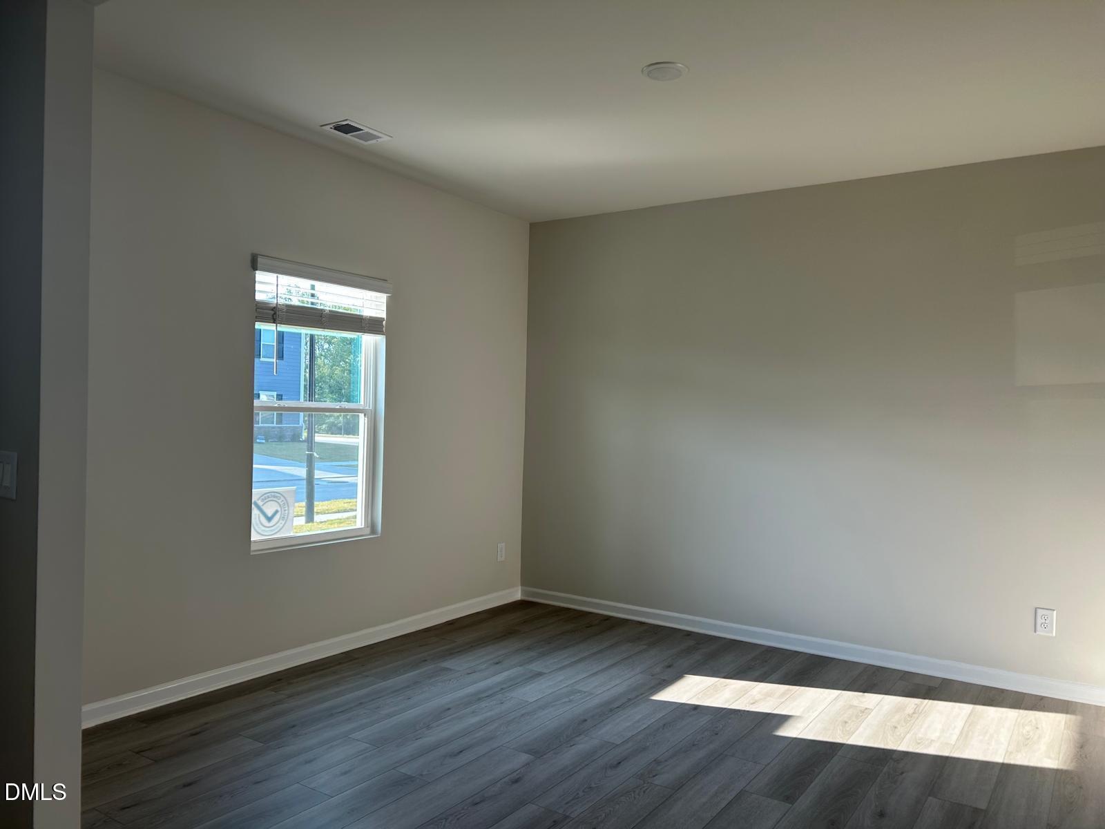 1220 Whitespire Way Zebulon, NC 27597 - Photo 16 of 20 an empty room with wooden floor and windows
