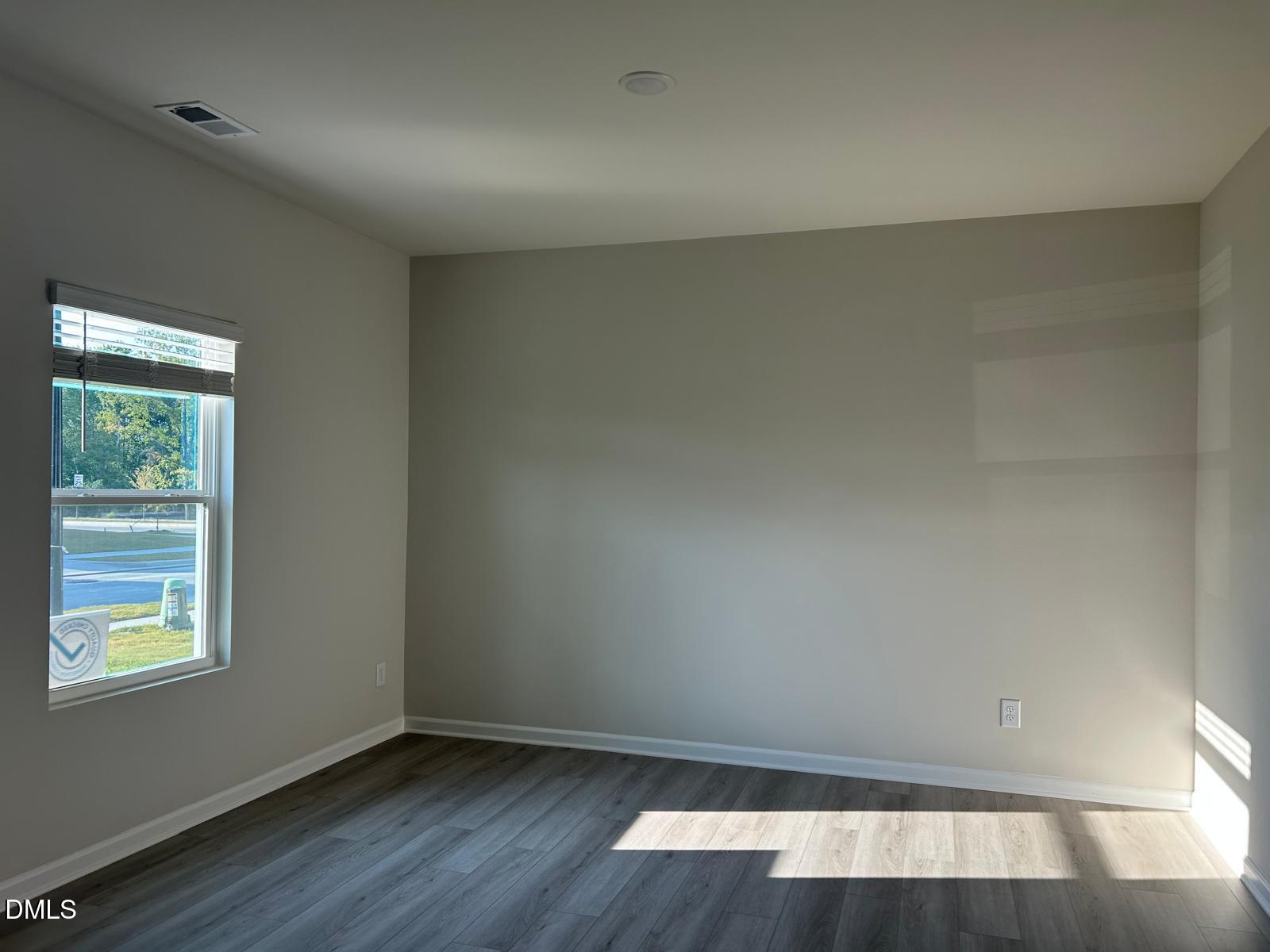 1220 Whitespire Way Zebulon, NC 27597 - Photo 17 of 20 an empty room with wooden floor and windows